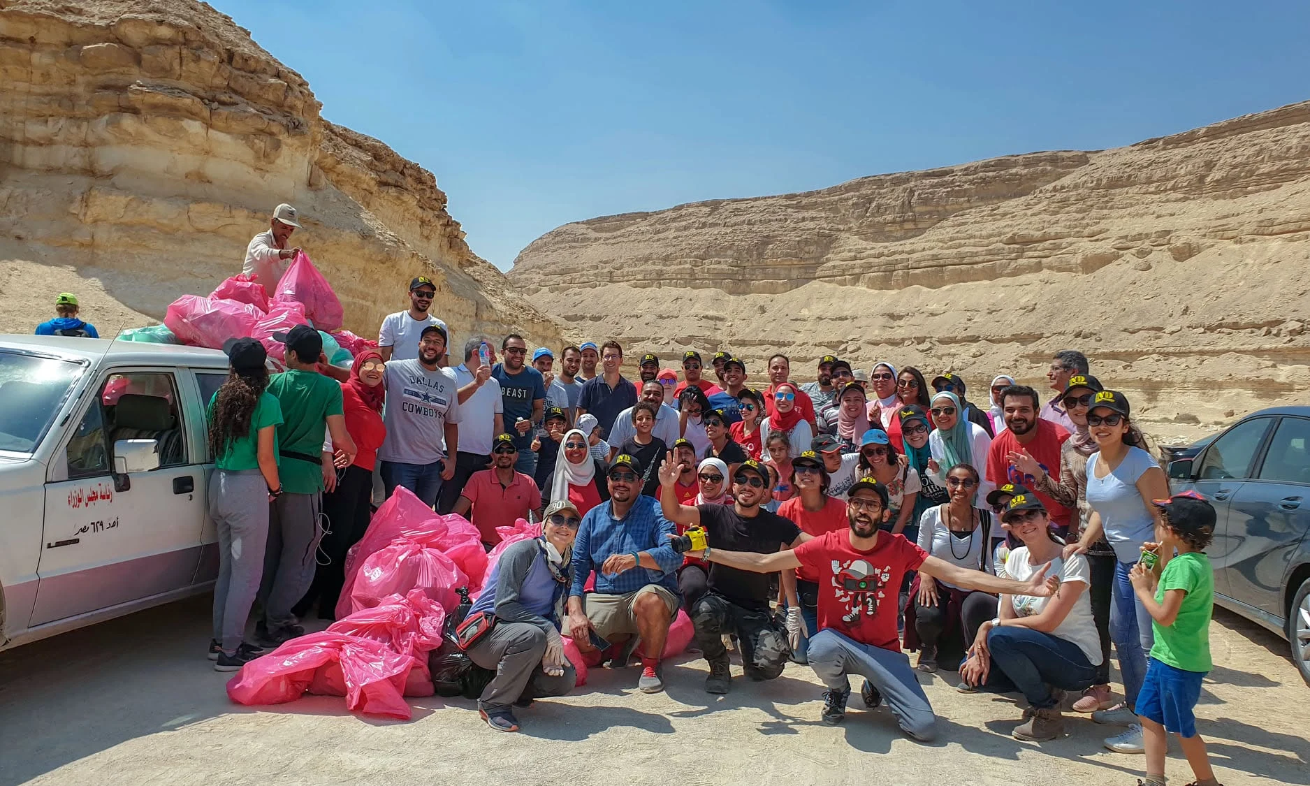 متطوعو ناشونال ديسكفري مجتمعون مع المخلفات المجمعة بعد حملة تنظيف صحراوية