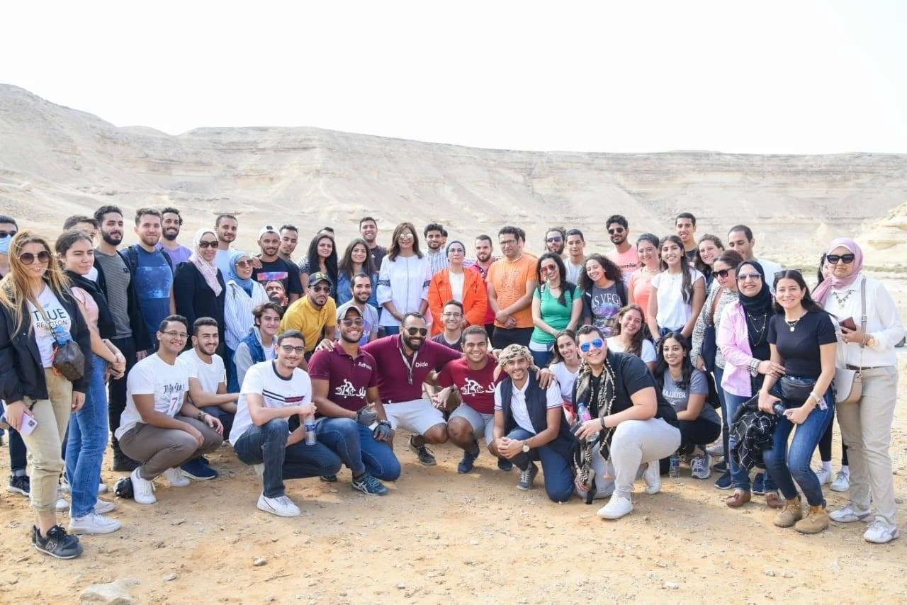 أعضاء من شباب ومغامري مجتمع ناشونال ديسكفري مجتمعون في مشهد صحراوي مصري